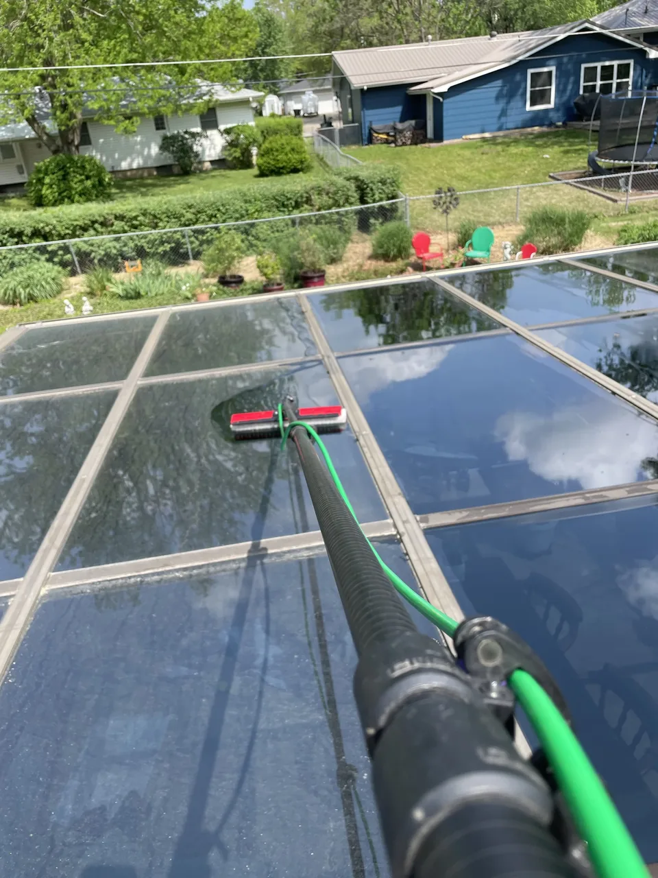 Cleaning the angled glass roof panels of a residential sunroom